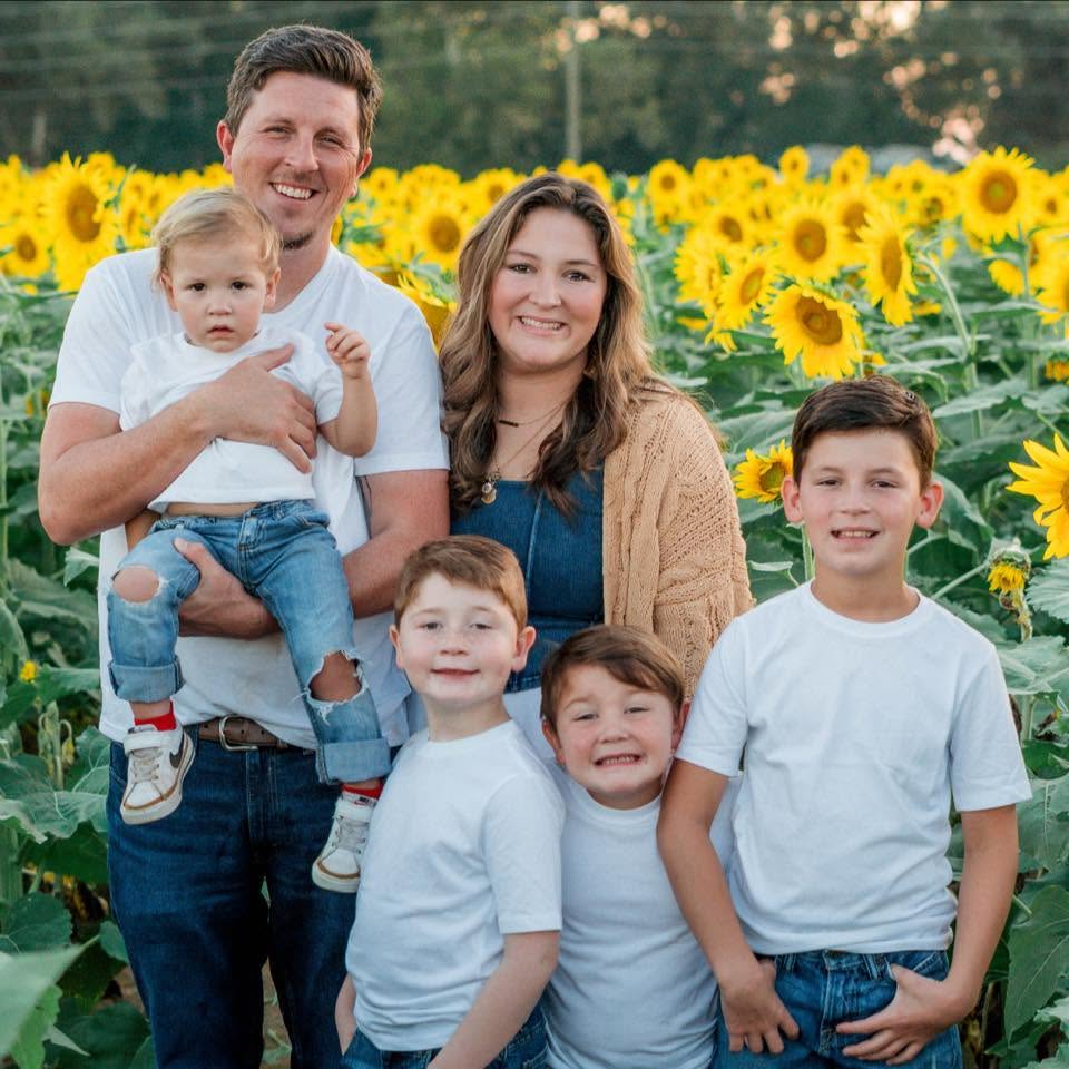 Aaron Joseph Hall with his family in a field of sunflowers